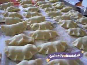 Pierogi z jagodami w trakcie przygotowania na stolnicy.