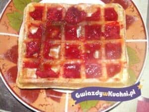 Delikatne gofry z dżemem na talerzu, idealne na śniadanie.