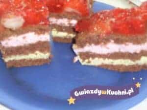 Ciasto diabełek z warstwami i polewą truskawkową na niebieskim talerzu.