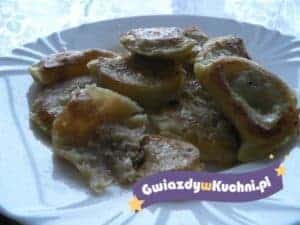 Smażone pierogi z kapustą i grzybami na talerzu.