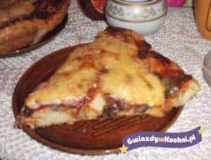 Domowa pizza z serem i warzywami na drewnianym talerzu.