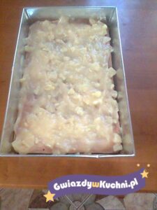 Ciasto biszkoptowe z masą ananasową w formie do pieczenia.