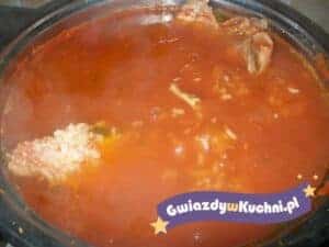 Zupa pomidorowa z ryżem w garnku, gorąca i aromatyczna, z kawałkami mięsa.