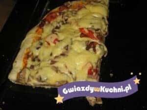 Pizza z pieczarkami i serem, gotowa do podania na czarnym tle.