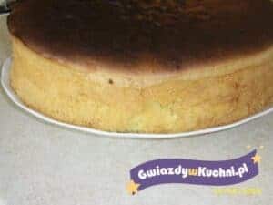 Duży biszkopt XXL z lekko przypieczoną górą na białym talerzu.