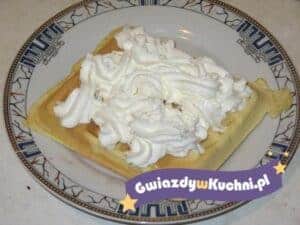 Domowe gofry z bitą śmietaną na talerzu.