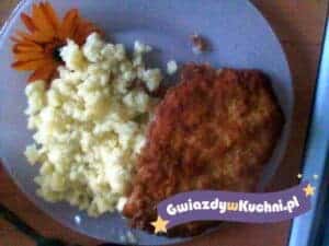 Kotlet schabowy z ziemniaczanym puree i dekoracją kwiatową.