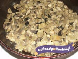 Smażone pieczarki z czosnkiem na patelni, idealne do dań kuchni polskiej.