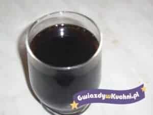 Czarna cola w szklance na białym tle, idealna do napoju.