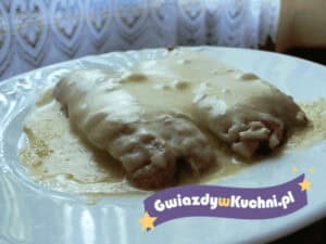 Zapiekane parówki z serem na białym talerzu, gotowe do podania.