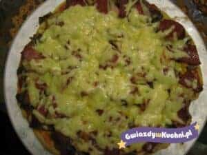 Pizza z tuńczykiem i serem, podana na talerzu, apetyczny wygląd.